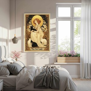 May include: A framed art print featuring a woman with red hair, surrounded by cats. The artwork has a vintage style with gold and cream tones. The text "The Cat Lady" is at the bottom of the print.