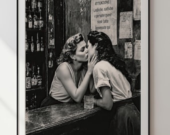 以下が含まれることがあります： バーカウンターでキスをする二人が描かれたモノクロの額入りアートプリント。壁の看板には「ATTENZIONE! Lesbiche, saffiche e persone queer sono tutte benvenute qui」と書かれている。バーの後ろの棚にはボトルが並んでいる。