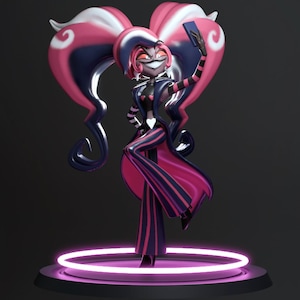 Może przedstawiać: Figurka 3D postaci z różowymi, białymi i granatowymi włosami ułożonymi w kształt serca. Postać ma na sobie czarno-różowy strój i robi selfie smartfonem. Figurka stoi na okrągłej platformie z neonowym różowym światłem.