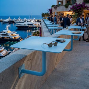 Könnte beinhalten: Ein hellblauer, quadratischer, wandmontierter Metalltisch mit einem einzelnen Stützarm an einem Steinvorsprung. Auf der Tischoberfläche liegen eine Sonnenbrille mit Schildpattmuster und ein dunkles Smartphone nahe der Tischkante.