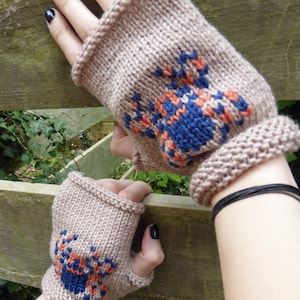 May include: A pair of brown fingerless gloves with a blue and orange crab design knitted into the fabric.