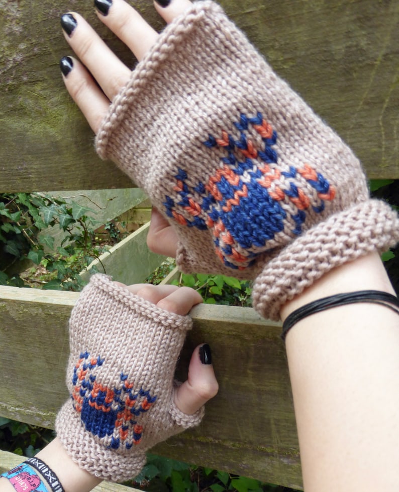 May include: A pair of brown fingerless gloves with a blue and orange crab design knitted into the fabric.