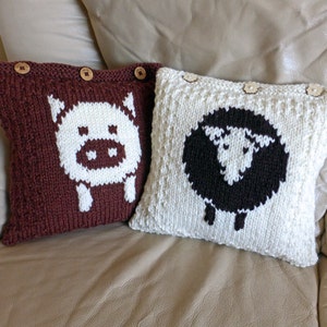 May include: Two knitted pillow covers with animal designs. The brown pillow cover features a white pig with a pink nose. The white pillow cover features a black sheep with a white face.