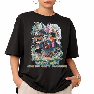 May include: Black t-shirt featuring a colorful graphic of animated animal characters. The design includes the text "we're wild and we can't be tamed" in a rainbow font. The shirt has short sleeves and a crew neck.