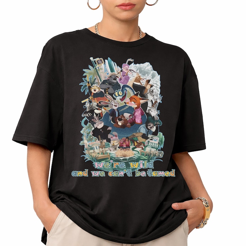 May include: Black t-shirt featuring a colorful graphic of animated animal characters. The design includes the text "we're wild and we can't be tamed" in a rainbow font. The shirt has short sleeves and a crew neck.