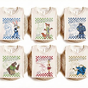Puede incluir: Seis camisetas de color blanco roto con personajes de Zootopia: Judy Hopps, Nick Wilde, Chief Bogo, Flash, Gazelle y Clawhauser. Cada camiseta muestra una ilustraci&oacute;n del personaje, su nombre en cursiva, un borde a cuadros y un a&ntilde;o.