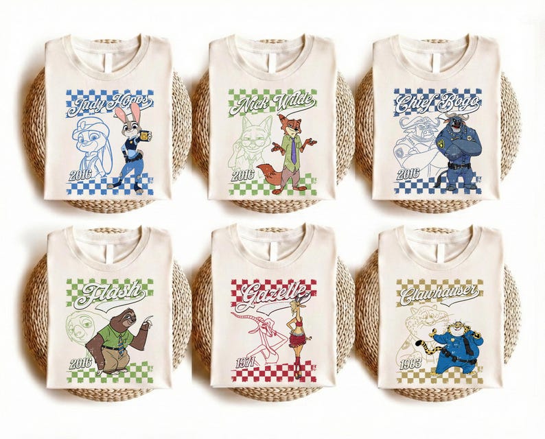 Puede incluir: Seis camisetas de color blanco roto con personajes de Zootopia: Judy Hopps, Nick Wilde, Chief Bogo, Flash, Gazelle y Clawhauser. Cada camiseta muestra una ilustraci&oacute;n del personaje, su nombre en cursiva, un borde a cuadros y un a&ntilde;o.