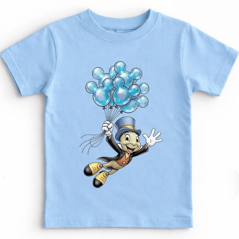 May include: Light blue t-shirt featuring a cartoon illustration of Jiminy Cricket holding a bouquet of blue Mickey Mouse-shaped balloons. Jiminy Cricket is wearing a top hat and a black suit. The balloons have a glittery effect.