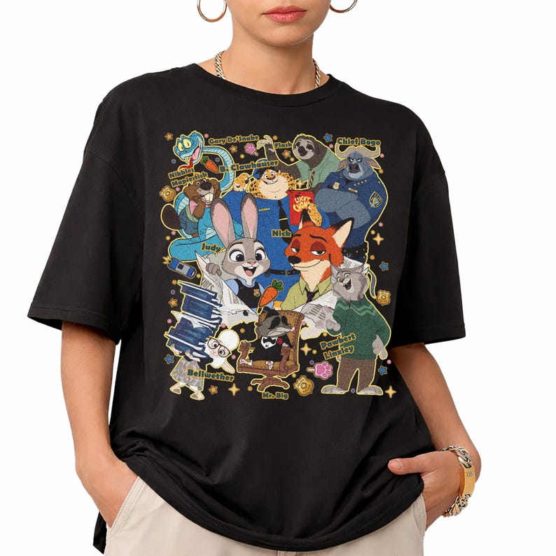 Op de afbeelding: Zwart t-shirt met een kleurrijke afbeelding van personages uit de animatiefilm Zootopia. Het ontwerp bevat Judy Hopps, Nick Wilde en andere personages. Het shirt heeft korte mouwen en een ronde hals.