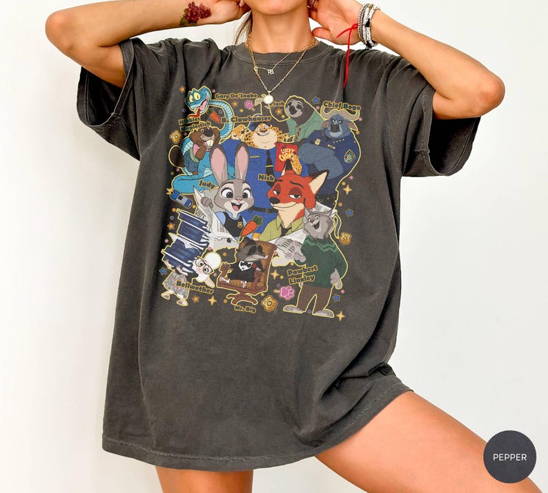 Op de afbeelding: Donkergrijze t-shirt met een kleurrijke afbeelding van personages uit de animatiefilm Zootopia. Het ontwerp bevat Judy Hopps, Nick Wilde en andere personages. Het shirt heeft een vintage, versleten uitstraling.