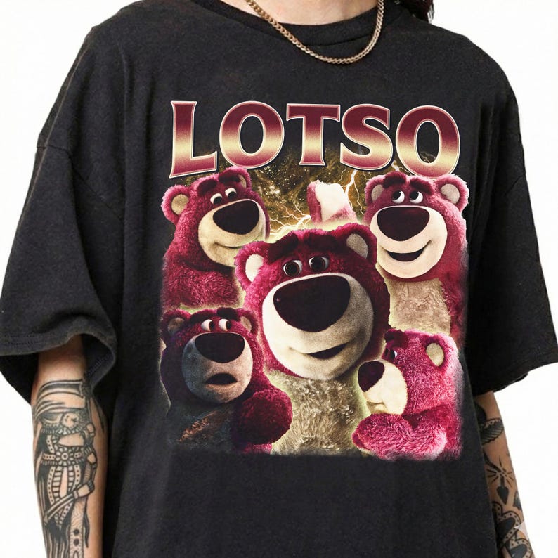May include: Black t-shirt featuring a graphic of Lotso, the pink bear from Toy Story, with the word "LOTSO" in a gold and red font. The bear graphic has a variety of expressions.