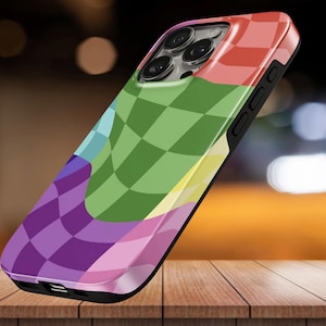 May include: A smartphone case featuring a distorted, wavy checkerboard pattern in vibrant shades of green, purple, pink, yellow, and red. The case has a black frame, precise cutouts for the camera lenses, and side buttons for volume and power.