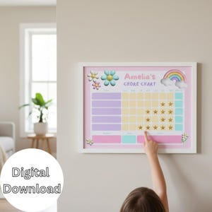 Peut inclure: Un tableau de corvées encadré avec un fond rose, représentant un arc-en-ciel, des fleurs et le texte "Amelia's CHORE CHART". Le tableau comporte des espaces pour les tâches et les récompenses, avec des autocollants en forme d'étoiles dorées.