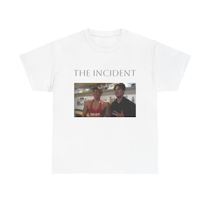Puede incluir: Camiseta blanca con el texto "THE INCIDENT" impreso en negro. Debajo del texto hay una fotografía de dos hombres. Uno lleva una camiseta sin mangas roja con la palabra "INZER".
