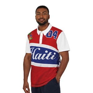 May include: A red, white, and blue polo shirt with the word "Haiti" across the chest. The shirt has white sleeves and a white collar. The number "04" is printed on the upper right chest.