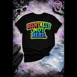 May include: Black t-shirt with the text "MENTALLY NOT HERE" in a colorful, outlined font. The shirt is paired with denim shorts, black shoes, and sunglasses. The overall theme is casual and humorous.