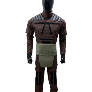 May include: A set of three ceramic mugs with a speckled, matte finish. The mugs are in shades of cream, light grey, and dark grey. Each mug has a simple, minimalist design and a rounded handle.