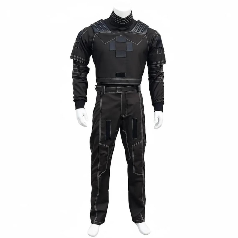 Puede incluir: Mono negro con costuras blancas. El atuendo presenta un cuello alto, mangas largas y paneles reforzados en los hombros y el pecho. Los pantalones tienen un dise&ntilde;o de pierna recta. El estilo general sugiere un tema futurista o t&aacute;ctico.