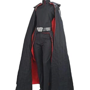 May include: A black costume with a red-lined cape, featuring a high-collared jacket, matching pants, and a belt. The costume includes shoulder accents and a small emblem on the sleeve, displayed on a mannequin.