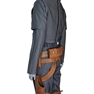 May include: A gray jacket and pants ensemble with a brown leather belt and holster. The jacket has a high collar and a zipper down the back. The belt features multiple pouches and a leg strap.