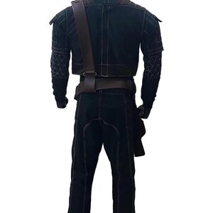 May include: Black outfit with white stitching, featuring a cropped jacket, pants, and a brown leather strap across the chest. The jacket has geometric patterns on the sleeves. The outfit includes a belt and a holster.