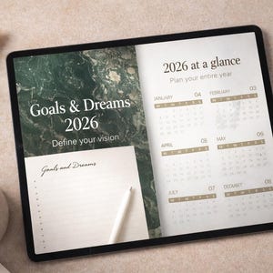 Könnte beinhalten: Ein digitaler Planer auf einem Tablet zeigt den Text "Goals & Dreams 2026" und "Define your vision". Der Planer enthält einen Kalender für 2026 und einen Abschnitt zum Schreiben von Zielen. Eine Tasse Kaffee und ein Stift sind ebenfalls sichtbar.