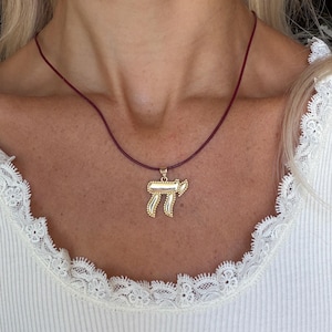 May include: A white ceramic mug with a black handle and the text "But First, Coffee" in a bold, black font. The mug is set against a blurred background, suggesting a cozy setting.