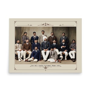 Op de afbeelding: Een ingelijste vintage foto van het 1st All India Cricket Team uit 1911. De afbeelding toont een groep mannen in formele kleding, zittend en staand, tegen een neutrale achtergrond. De foto is omlijst met een sierlijk ontwerp en de tekst "1st All India Cricket Team 1911".