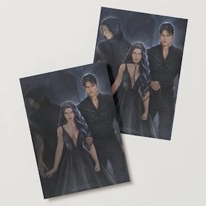 May include: Two art prints featuring illustrations of a woman in a black gown with a plunging neckline, a man in a black suit, and figures in dark cloaks. The prints have a fantasy theme and are set against a dark background.