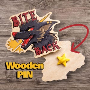 May include: Wooden pin featuring a black wolf with red eyes and open mouth, biting a yellow lightning bolt. The words "Bite Back" and "Wooden Pin" are displayed. A yellow star is also present.
