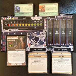 May include: A black plastic board game player dashboard featuring a numbered track from 0 to 12, four vertical reputation columns for Hutt, Syndicate, Imperial, and Rebel factions, and slots holding game cards including Han Solo and The Kessel Run.