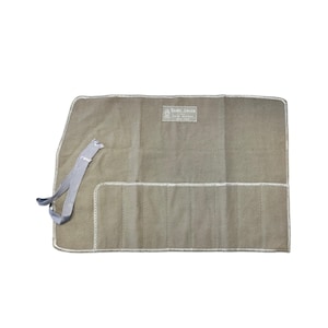 May include: A tan canvas tool roll with white stitching and a gray tie closure. The roll features multiple pockets for organizing tools. The label reads "Georg Jensen, New York".