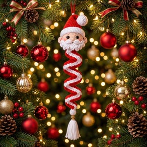Peut inclure: Une décoration de Noël en crochet représentant le Père Noël avec un corps en spirale rouge et blanc, une barbe blanche et un bonnet rouge à pompon blanc. L'ornement est suspendu par un fil rouge et se termine par un pompon blanc en bas.