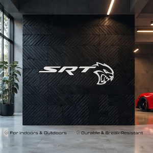 May include: White SRT logo and a stylized cat head emblem on a black textured wall. The text "For Indoors & Outdoors" and "Durable & Break-Resistant" are below the logo. A red sports car is partially visible in the background.