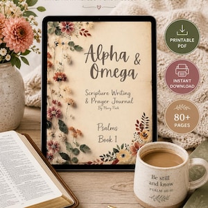 Puede incluir: Una tableta digital que muestra un diario de oración y escritura de las Escrituras titulado Alpha & Omega, Psalms Book 1 de Mary Park, con ilustraciones florales. Al lado hay una taza de cerámica con el texto Be still and know PSALM 46:10 y un bolígrafo dorado.