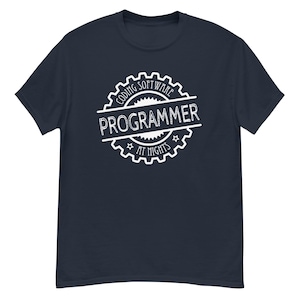 Puede incluir: Camiseta azul marino con un gráfico blanco. El gráfico es un diseño circular con las palabras "Coding Software Programmer at Nights" en una fuente estilizada. El diseño incluye un borde en forma de engranaje y acentos de estrella.