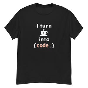 Può includere: T-shirt nera con la scritta "I turn into {code;}". Il design include un'icona di tazza di caffè sopra la parola "into". La parola "code" è rossa. Una maglietta divertente per programmatori.