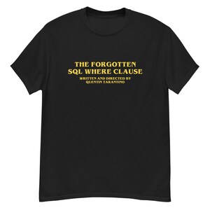 Puede incluir: Camiseta negra con el texto dorado "THE FORGOTTEN SQL WHERE CLAUSE". Debajo, en dorado, se lee "WRITTEN AND DIRECTED BY QUENTIN TARANTINO". La prenda es una camiseta de manga corta y cuello redondo.