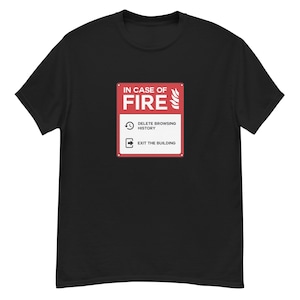 Puede incluir: Camiseta negra con un diseño gráfico rojo y blanco. El diseño muestra un letrero con la frase "IN CASE OF FIRE" y las instrucciones "DELETE BROWSING HISTORY" y "EXIT THE BUILDING". El diseño imita una señal de seguridad contra incendios.