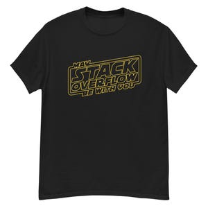 Op de afbeelding: Zwart T-shirt met een gele opdruk met de tekst "MAY STACK OVERFLOW BE WITH YOU". Het ontwerp is een parodie op een populair sciencefiction-filmlogo. Het shirt heeft een ronde hals en korte mouwen.