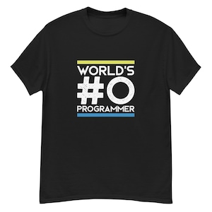 Puede incluir: Camiseta negra con el texto "WORLD'S #0 PROGRAMMER" en blanco, amarillo y azul. El diseño presenta una fuente en negrita y un diseño sencillo, perfecto para programadores.