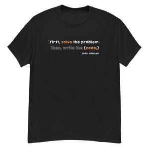 May include: Black t-shirt featuring the quote "First, solve the problem. Then, write the {code;}" in white and orange text, attributed to John Johnson. A simple, everyday tee.