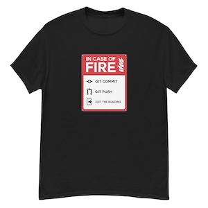 Puede incluir: Camiseta negra con un diseño rojo y blanco que dice "IN CASE OF FIRE" (en caso de incendio). Las instrucciones son "GIT COMMIT", "GIT PUSH" y "EXIT THE BUILDING". La camiseta es de material suave.