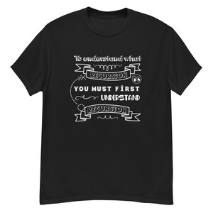 Puede incluir: Camiseta negra con texto blanco: "Para entender qué es la recursión, primero debes entender la recursión". El texto está en una fuente estilizada. La camiseta es de cuello redondo.