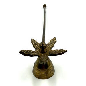 May include: A vintage brass oil lamp filler with a starburst design. The lamp filler has a bell-shaped base, a decorative starburst, and a long, slender spout. The brass has a warm, aged patina.