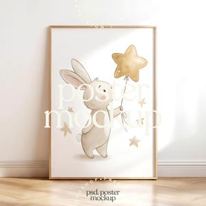 May include: A framed art print features a watercolor illustration of a bunny holding a gold star balloon. The bunny is light brown with long ears and a small tail. Several gold stars are scattered around the bunny. The print is in a wooden frame.