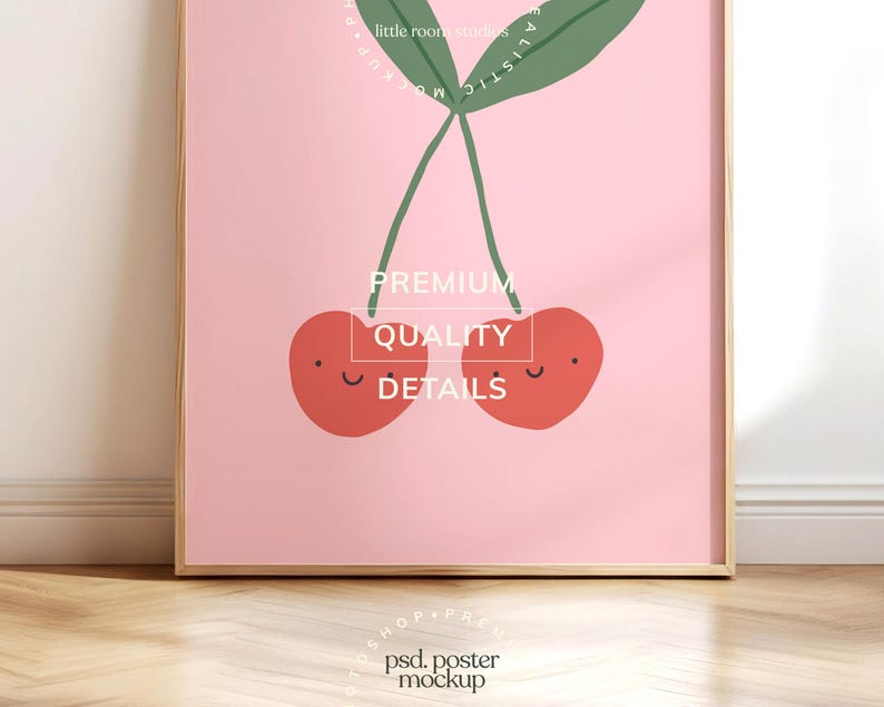 May include: A framed art print featuring a pair of smiling red cherries with green stems and leaves against a pink background. The print includes the text "PREMIUM QUALITY DETAILS".