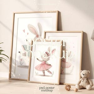 Puede incluir: Tres impresiones artísticas enmarcadas con ilustraciones de conejos. Una muestra una conejita bailarina con tutú rosa. Los marcos de madera clara están sobre un suelo claro. Un osito de peluche y un sonajero de madera están en primer plano. Ideal para una guardería.