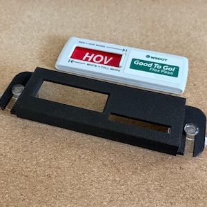May include: A black plastic holder with a rectangular opening, designed to hold a white and green Flex Pass. The pass has the text "Good To Go!" and "HOV" in red. The holder has suction cups.