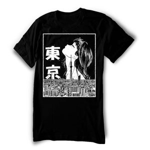 Puede incluir: Camiseta negra con un estampado gr&aacute;fico blanco de la cara de una mujer y la palabra japonesa "Tokio" en texto blanco.